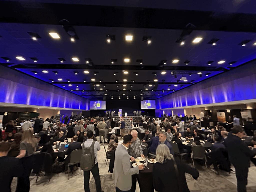 Attendees networking across a busy AiSK event floor