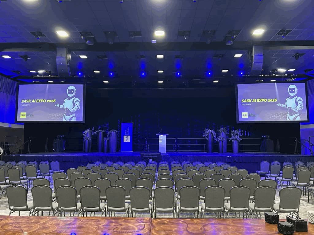 Empty SASK AI EXPO hall with stage screens and seating
